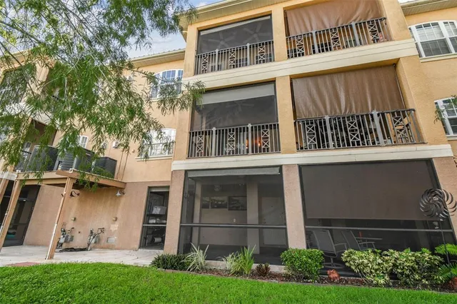 a view of a house with a yard and a large tree