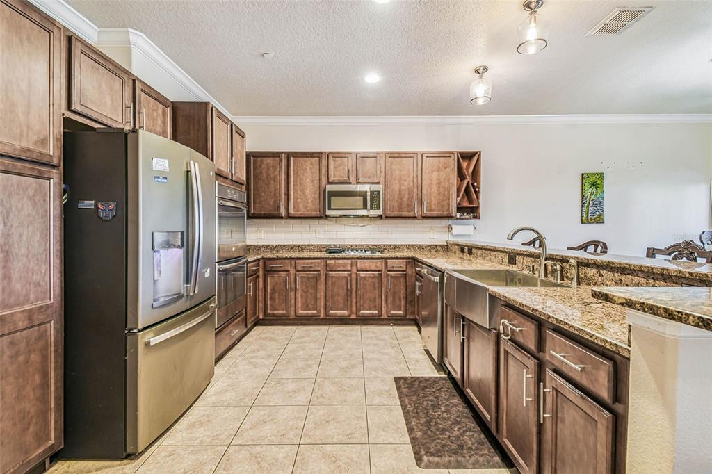 6533 Channelside Drive New Port Richey, FL 34652 - Photo 5 of 44 a large kitchen with stainless steel appliances granite countertop a refrigerator and a sink