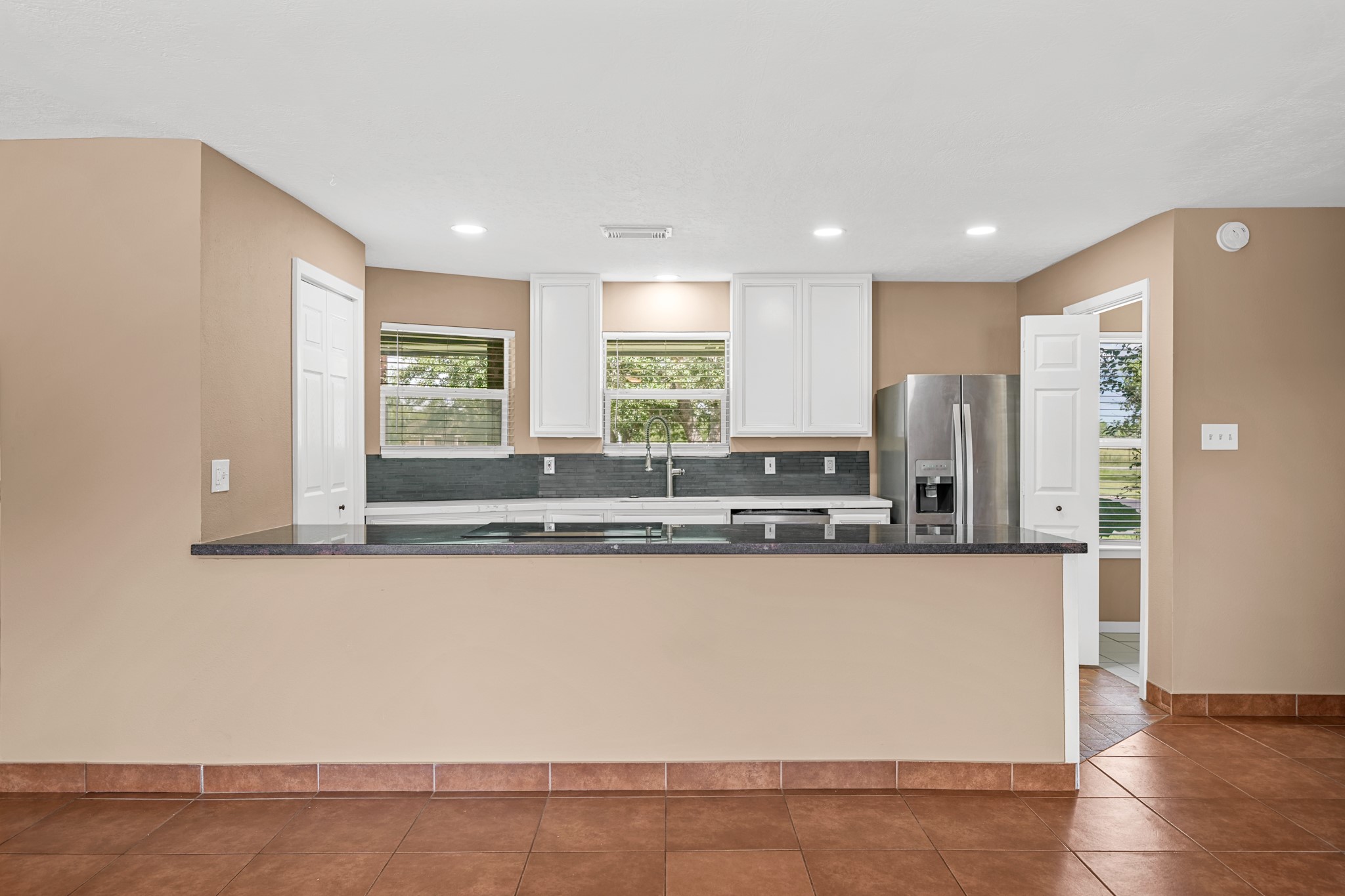 4435 South Tower Road Santa Fe, TX 77517 - Photo 13 of 35 Recently remodeled, the kitchen features granite countertops, custom wood cabinetry, updated finishes, and a large breakfast bar overlooking the living room.