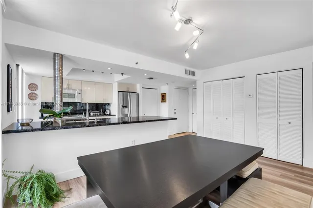 a kitchen with stainless steel appliances granite countertop a sink a stove and a wooden floors