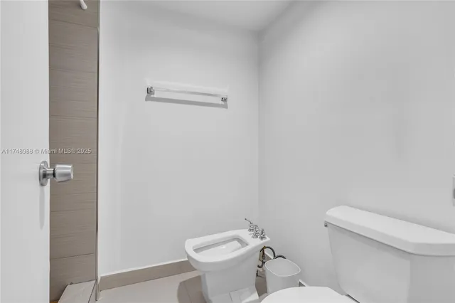 a white toilet sitting next to a white sink and vanity