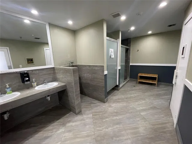 a bathroom with a sink a toilet and a large mirror