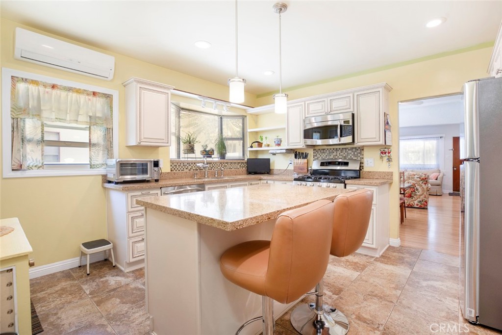 1130 Park Avenue Glendale, CA 91205 - Photo 31 of 75 a kitchen with stainless steel appliances granite countertop a stove a sink a refrigerator a microwave oven with a dining table and chairs