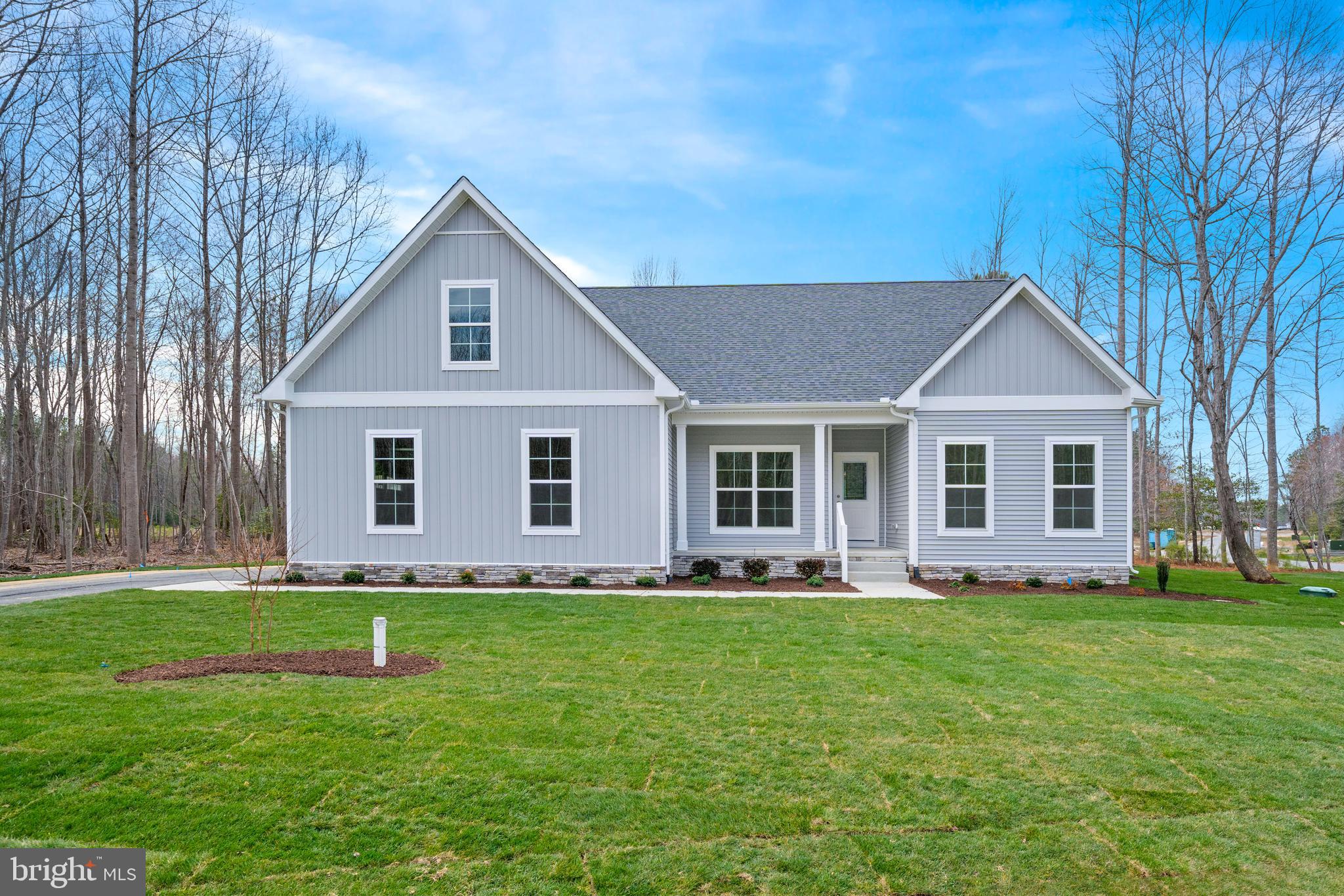 22598 Hummingbird Road, Unit 18 Ellendale, DE 19941 - Photo 2 of 15 a front view of house with a garden and trees