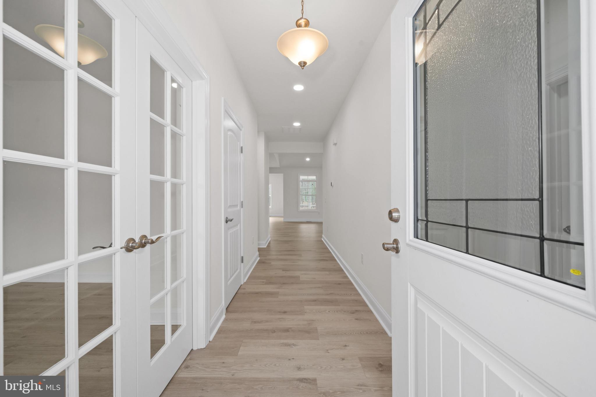 22598 Hummingbird Road, Unit 18 Ellendale, DE 19941 - Photo 4 of 15 a view of a hallway with wooden floor and staircase