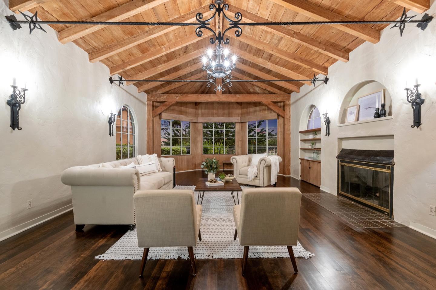 a living room with furniture a fireplace and a chandelier