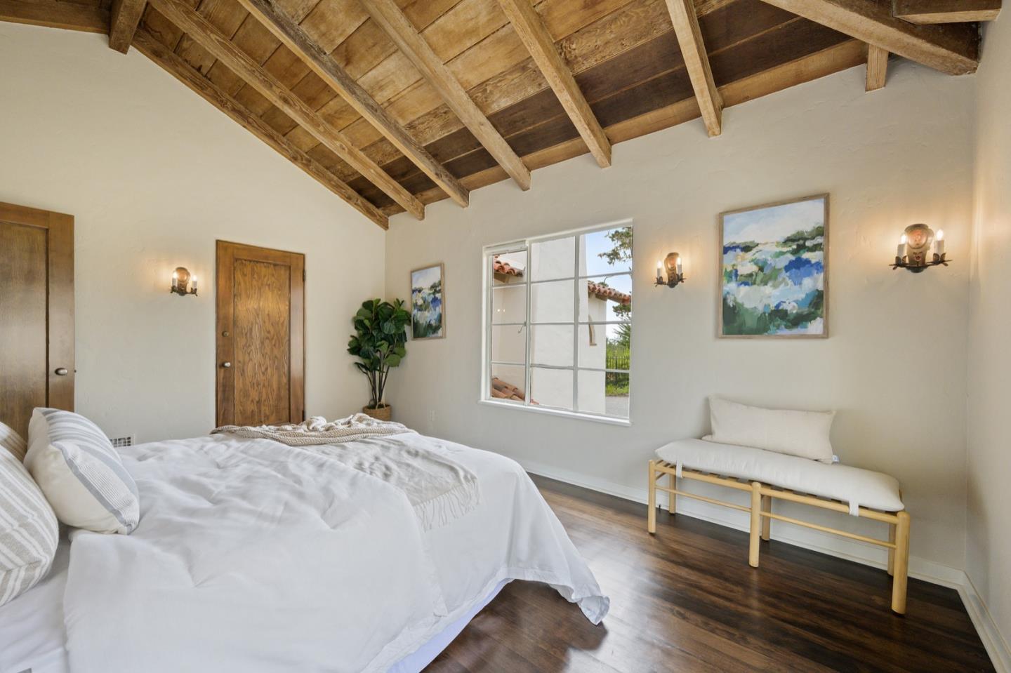3080 Bird Rock Road Pebble Beach, CA 93953 - Photo 28 of 46 a bedroom with a bed wooden floor and window