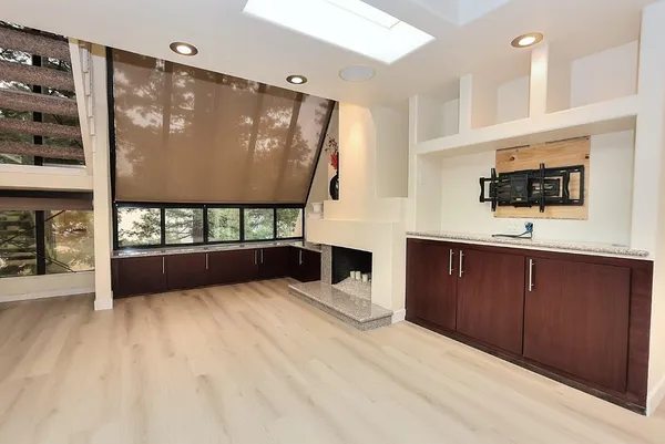 a living room with a fireplace windows and a television