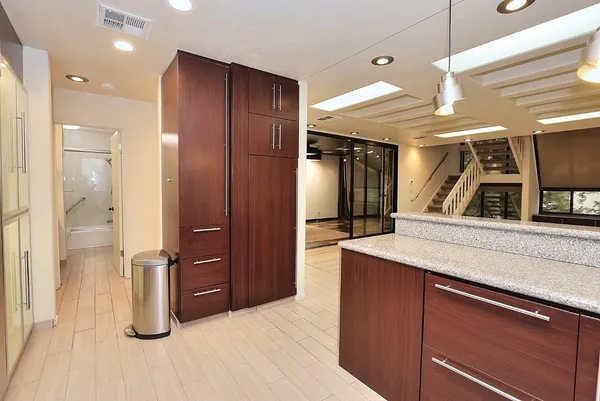 a view of an empty room with wooden floor and a bathroom