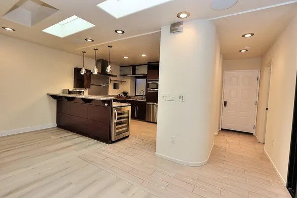 a spacious bathroom with a granite countertop sink a mirror and a bathtub