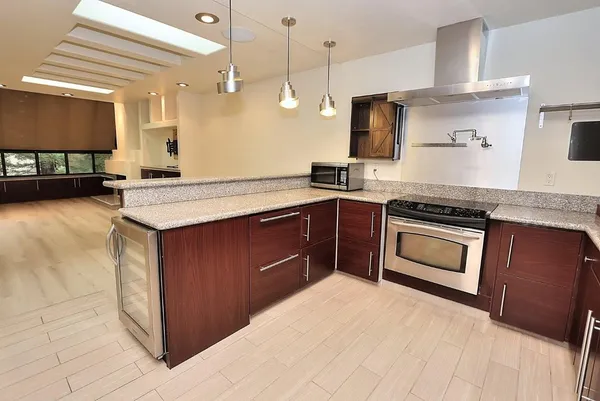 a kitchen with kitchen island a counter top space stainless steel appliances and cabinets