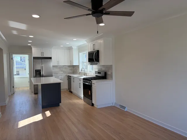a kitchen with a refrigerator and a stove top oven