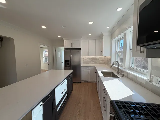a kitchen with kitchen island a sink stove and refrigerator