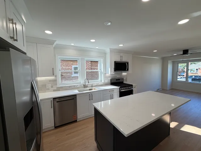 a kitchen with stainless steel appliances granite countertop a sink stove and refrigerator