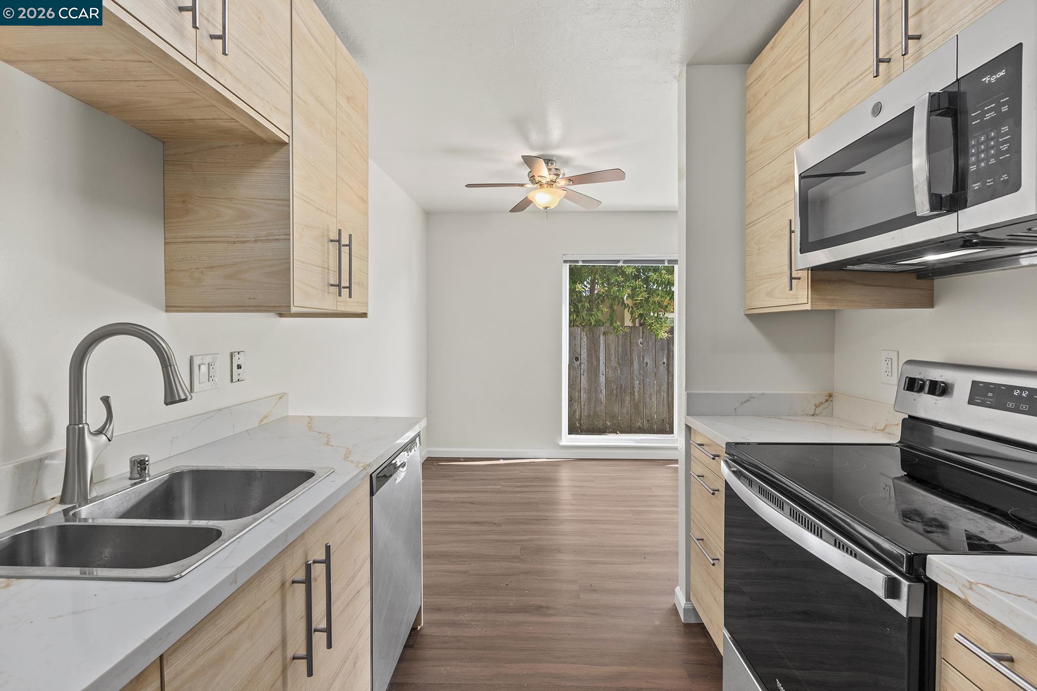 29 Leafwood Circle San Rafael, CA 94901 - Photo 5 of 34 a kitchen with stainless steel appliances granite countertop a sink dishwasher a stove and a microwave oven with wooden floor