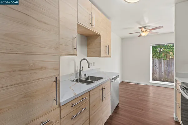 a kitchen that has a sink stainless steel appliances and cabinets