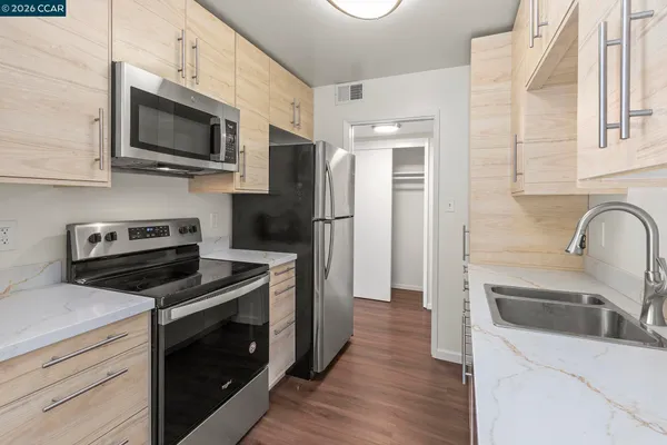 a kitchen with stainless steel appliances a stove microwave and a sink