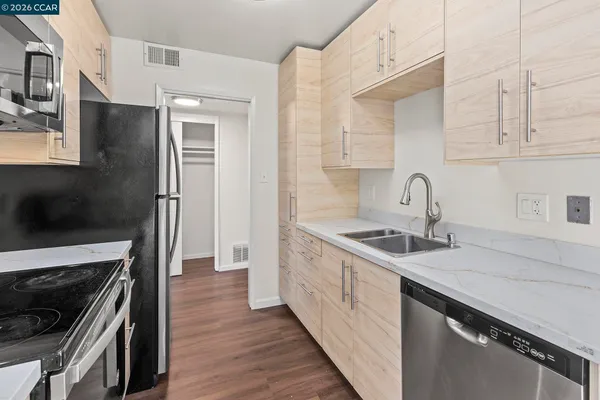 a kitchen with stainless steel appliances granite countertop a sink stove and refrigerator