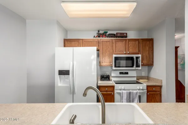 a kitchen with stainless steel appliances kitchen island a refrigerator sink and microwave