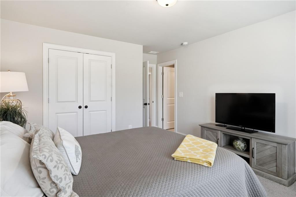 8840 Hightower Ridge Ball Ground, GA 30107 - Photo 33 of 74 a bedroom with a bed and a flat screen tv