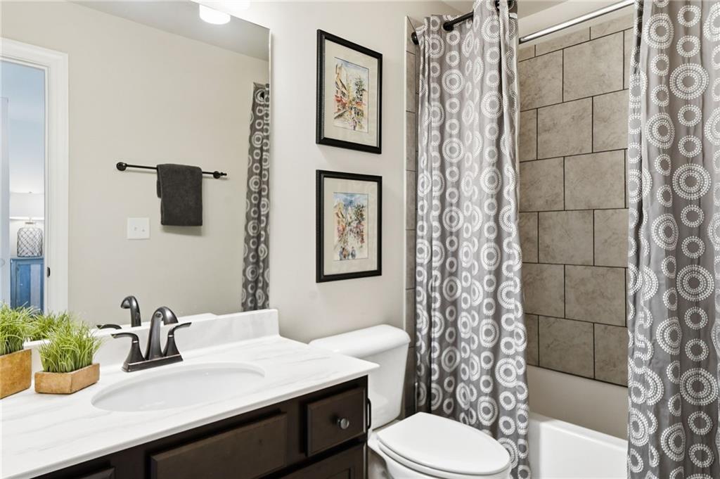 8840 Hightower Ridge Ball Ground, GA 30107 - Photo 34 of 74 a bathroom with a sink a toilet and shower curtain