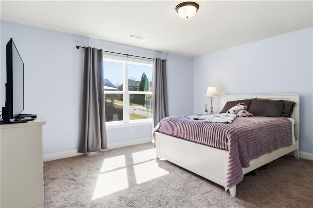 8840 Hightower Ridge Ball Ground, GA 30107 - Photo 35 of 74 a bedroom with a bed lamp and a window