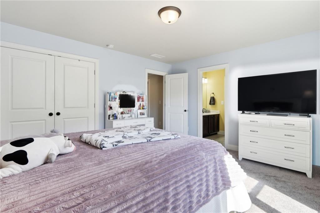 8840 Hightower Ridge Ball Ground, GA 30107 - Photo 36 of 74 a bedroom with a bed and flat screen tv