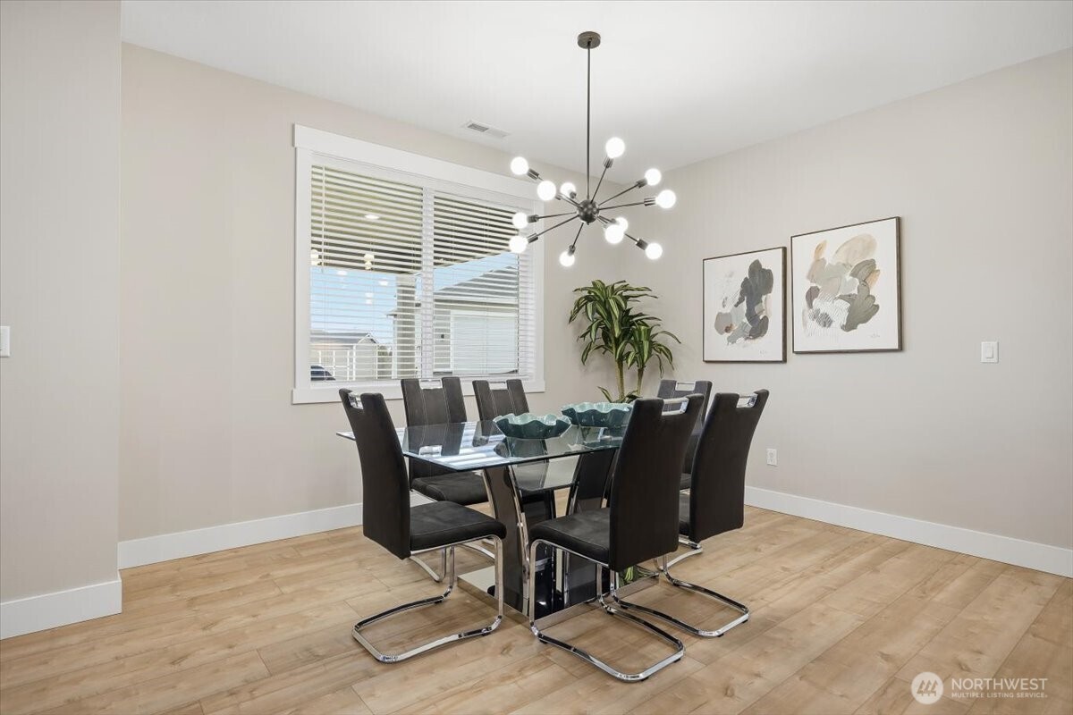 6915 Lamb Court Pasco, WA 99301 - Photo 15 of 40 a dining room with furniture a chandelier and wooden floor