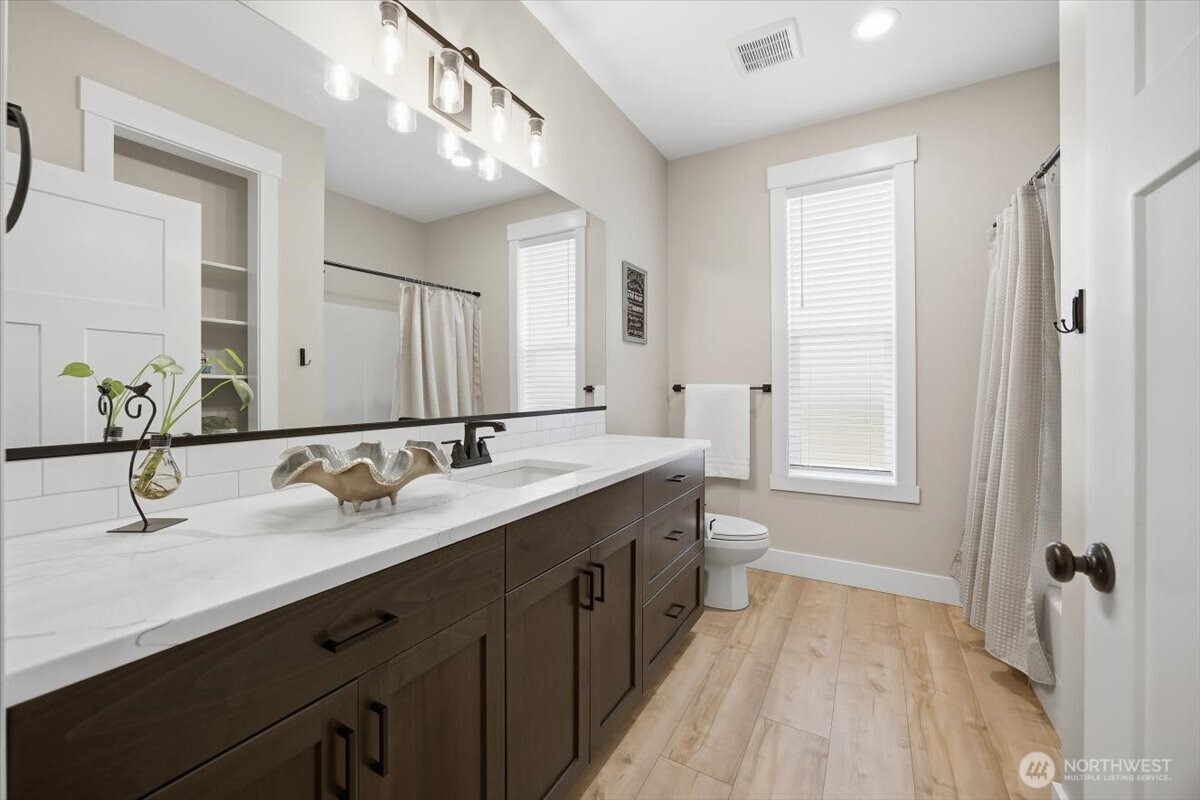 6915 Lamb Court Pasco, WA 99301 - Photo 24 of 40 a spacious bathroom with a double vanity sink a mirror and a bathtub
