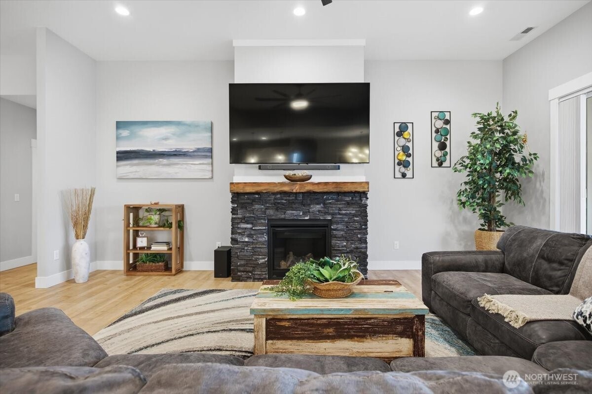 6915 Lamb Court Pasco, WA 99301 - Photo 8 of 40 a living room with furniture a flat screen tv and a fireplace