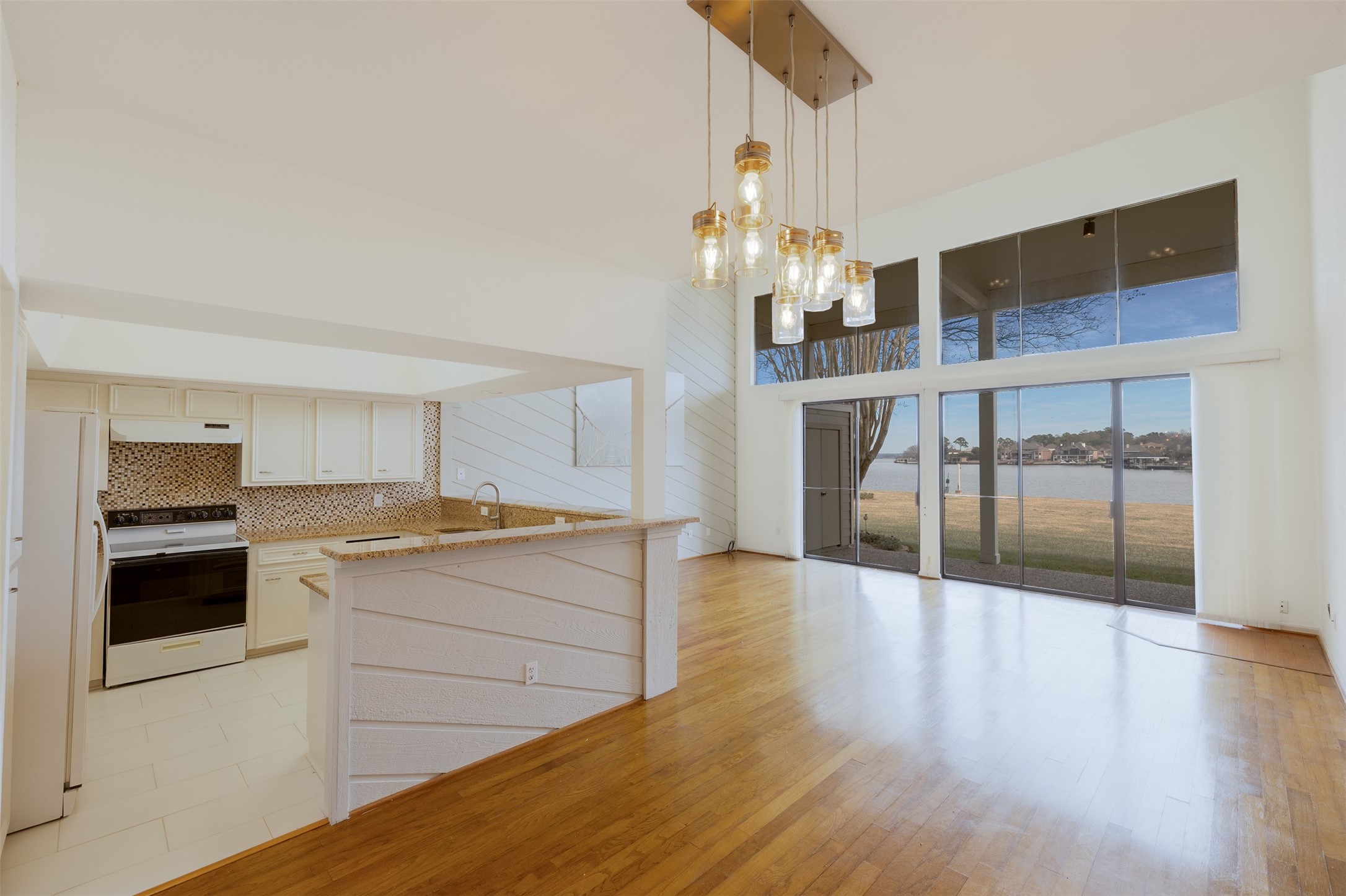 135 April Point Drive South Conroe, TX 77356 - Photo 17 of 45 Spectacular! Lake Conroe is framed beautifully by the wall of windows. Plus, you can see the open living area.