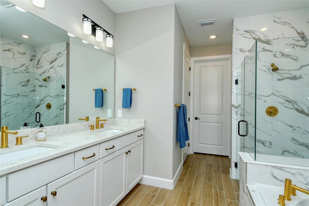 18114 Waterville Place Bradenton, FL 34202 - Photo 30 of 57 a bathroom with a granite countertop shower sink vanity and mirror