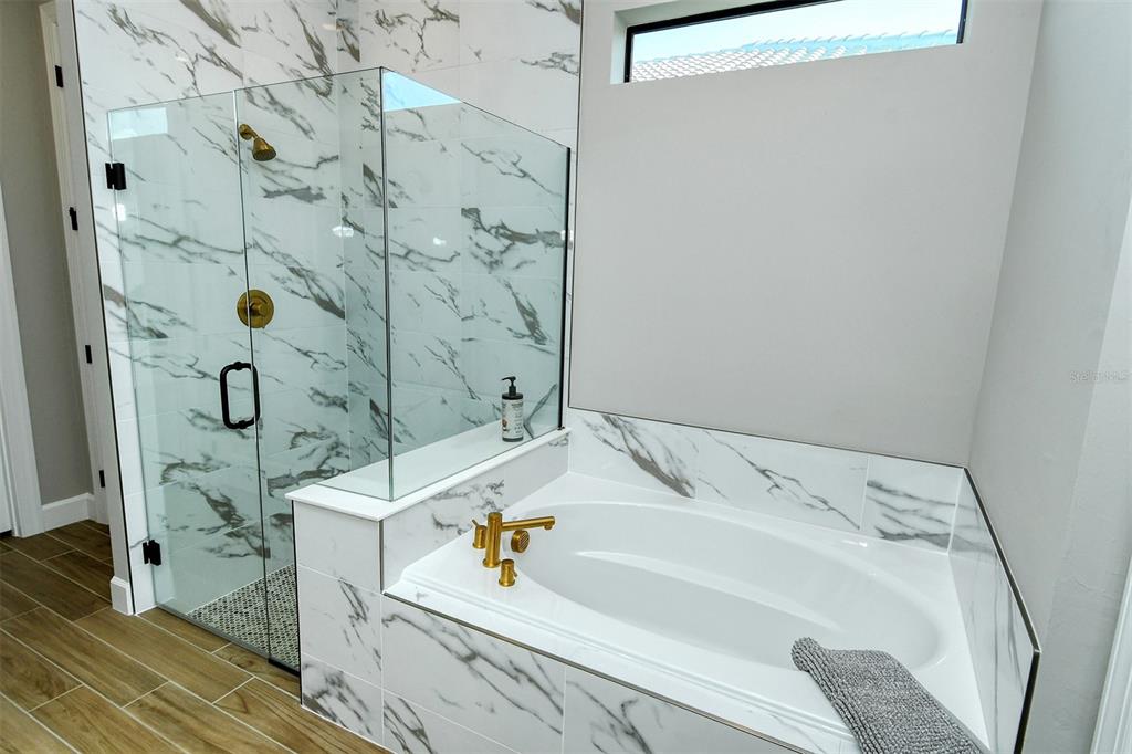 18114 Waterville Place Bradenton, FL 34202 - Photo 31 of 57 a bath tub sitting next to a white sink and vanity