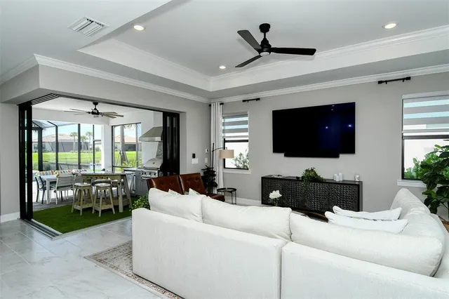 a living room with furniture a flat screen tv and a large window