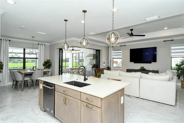 a view of a kitchen with kitchen island a sink a counter top space and living room view