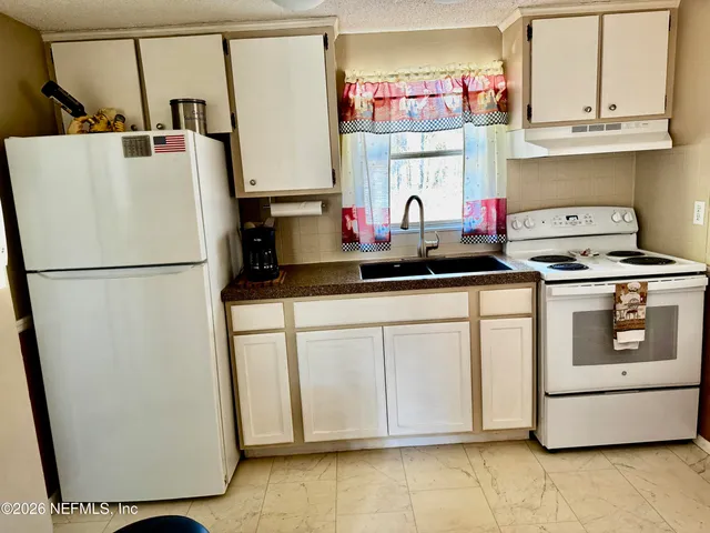 a kitchen with stainless steel appliances a refrigerator sink and cabinets