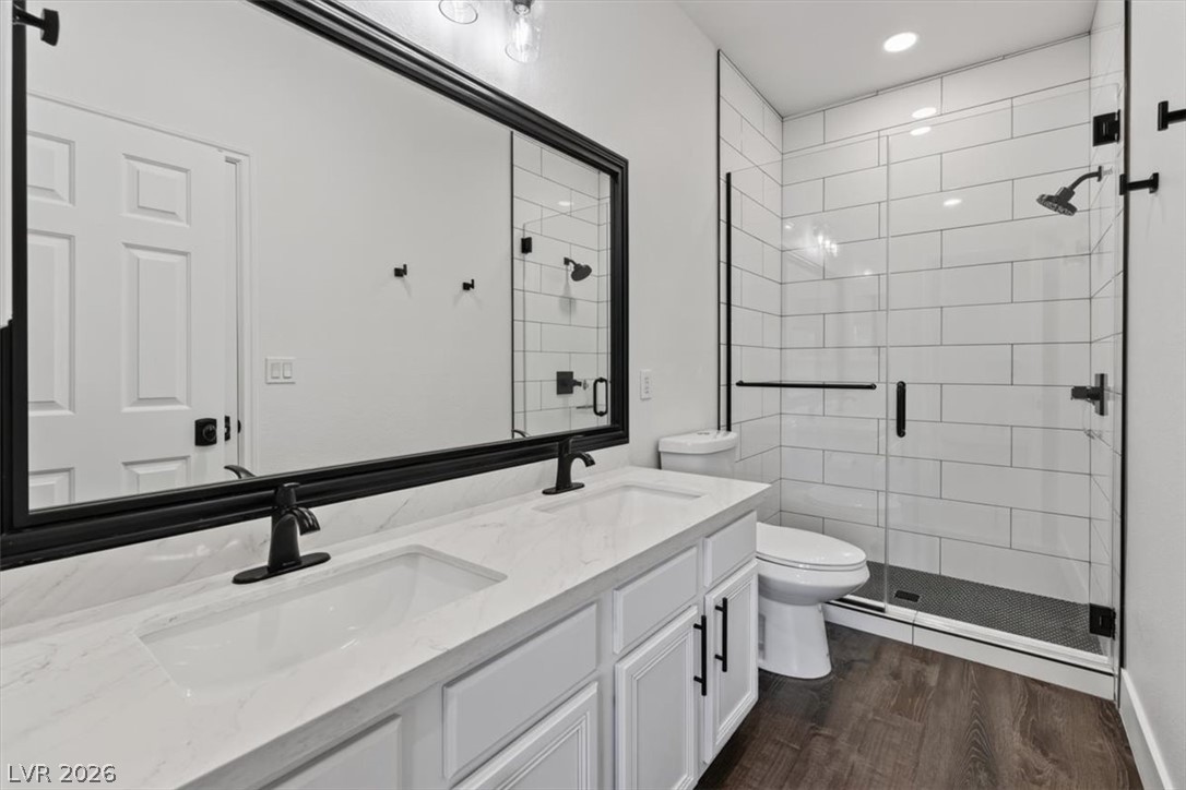 251 Integrity Ridge Drive Henderson, NV 89052 - Photo 18 of 32 Modern tile surrounds a glass-enclosed shower next to a double vanity.