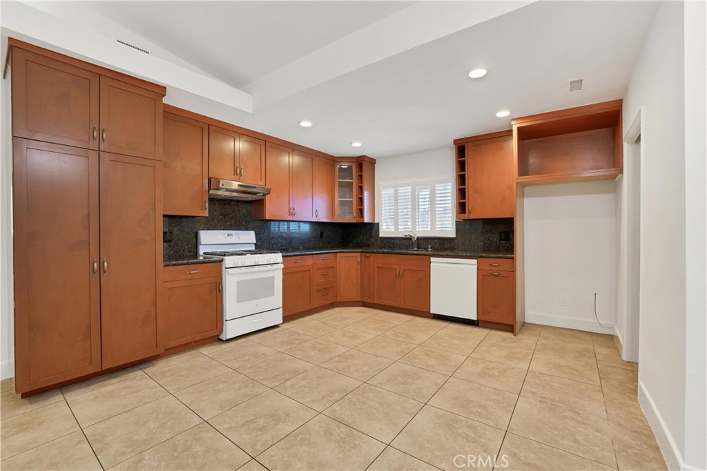 20300 Sherman Way Winnetka, CA 91306 - Photo 9 of 33 a kitchen with stainless steel appliances granite countertop a stove a sink and a refrigerator