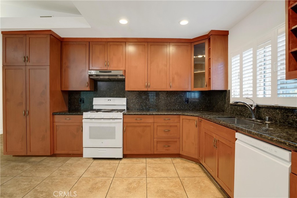 20300 Sherman Way Winnetka, CA 91306 - Photo 10 of 33 a kitchen with stainless steel appliances granite countertop a stove a sink and a granite counter tops