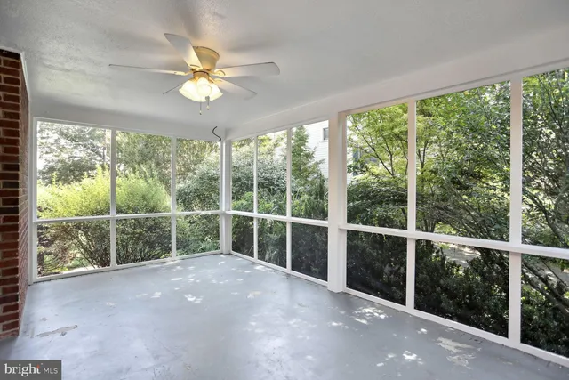 a view of a room with a large window and a ceiling fan