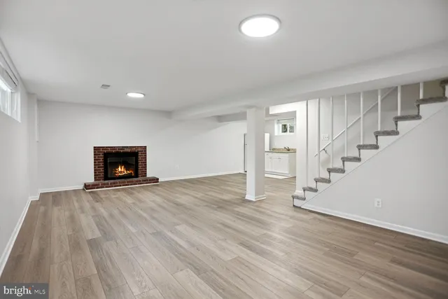 an empty room with wooden floor and fireplace