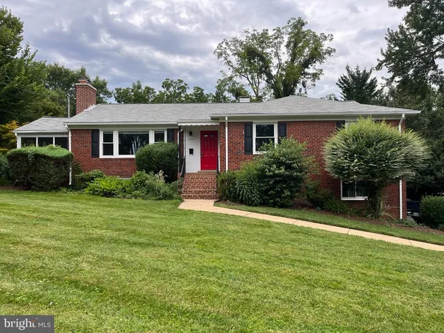 a front view of a house with a yard and potted plants