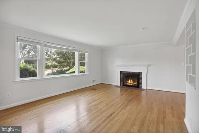 an empty room with windows and fireplace
