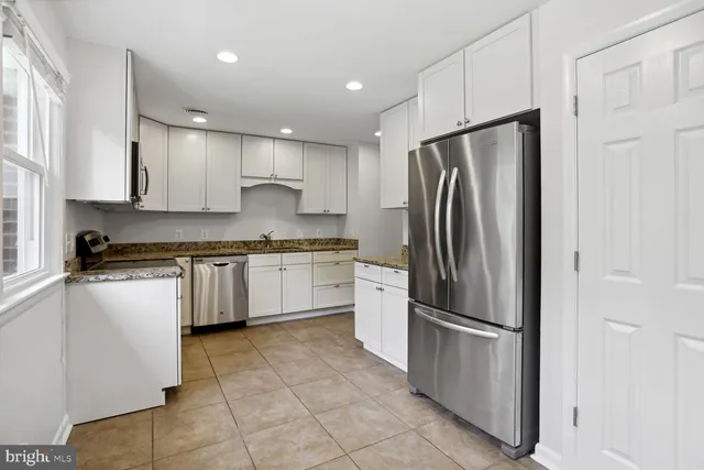 a kitchen with stainless steel appliances granite countertop a refrigerator sink and cabinets