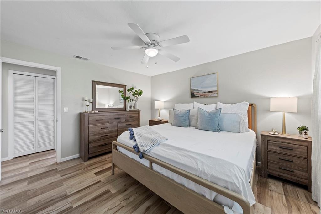 843 Palm View Drive, Unit 25 Naples, FL 34110 - Photo 20 of 27 a bedroom with a bed and wooden floor