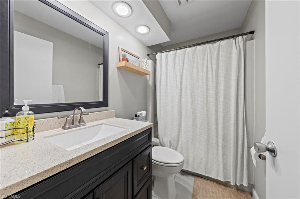 843 Palm View Drive, Unit 25 Naples, FL 34110 - Photo 21 of 27 a bathroom with a sink a toilet and shower curtain