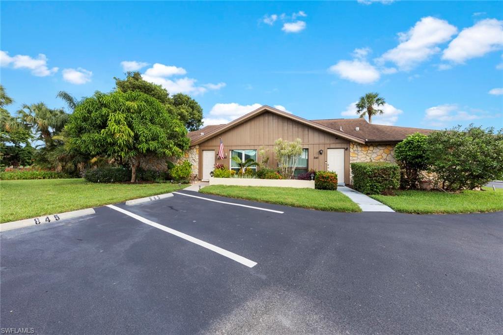 843 Palm View Drive, Unit 25 Naples, FL 34110 - Photo 22 of 27 a view of a house with a big yard and palm trees