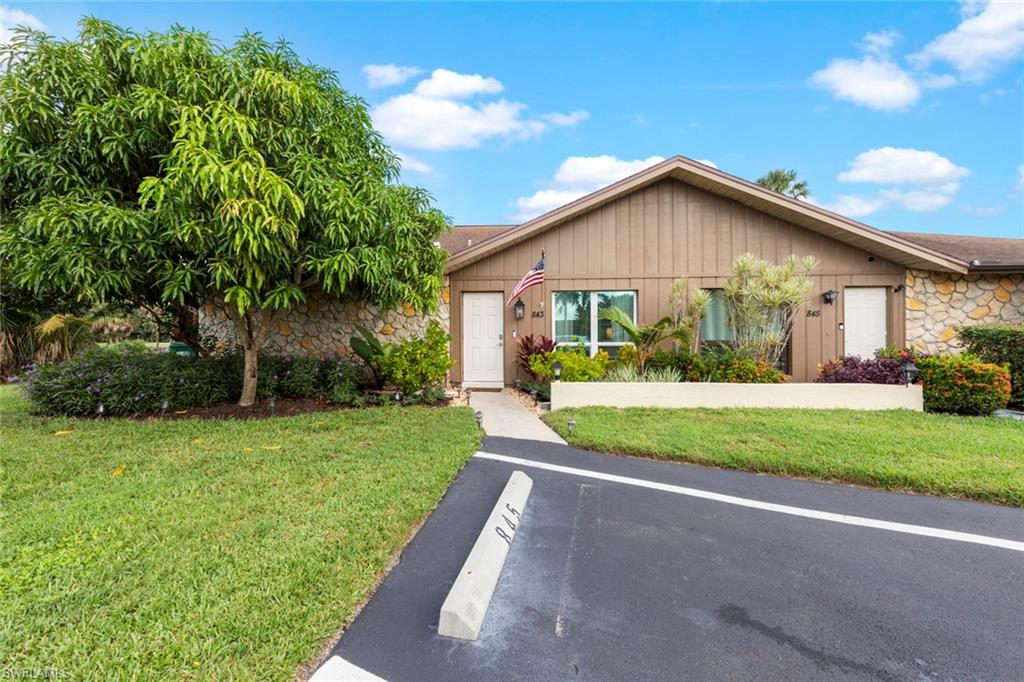 843 Palm View Drive, Unit 25 Naples, FL 34110 - Photo 23 of 27 a view of a house with a yard and potted plants
