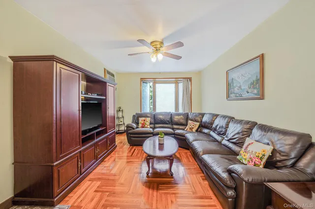 a living room with furniture and a large window with wooden floor