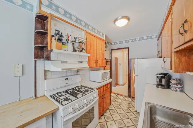 a kitchen with a sink a stove and cabinets